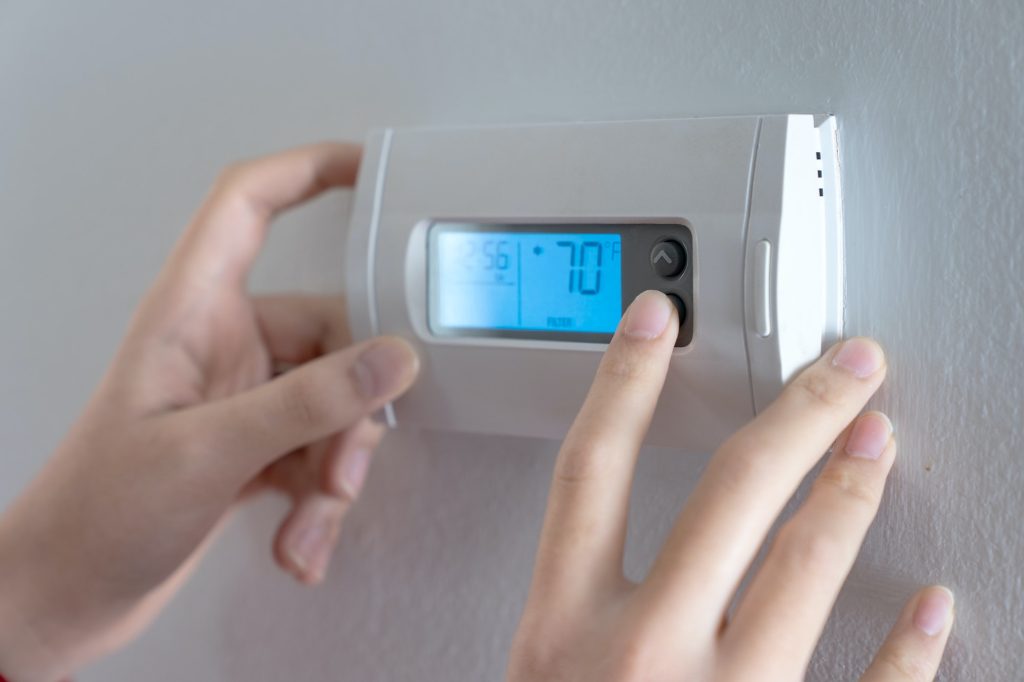 Hand press indoor room thermostat to lower the temp